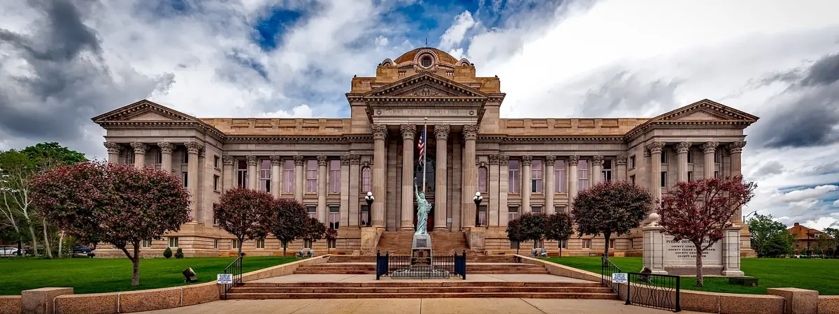 A neoclassical courthouse with stone columns and wide steps, a setting for criminal justice degree careers.